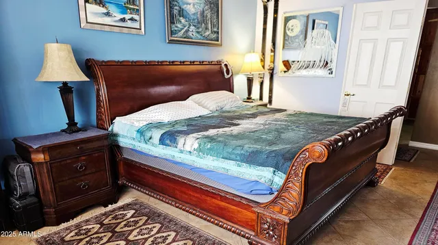 a bedroom with a bed and a lamp on dresser