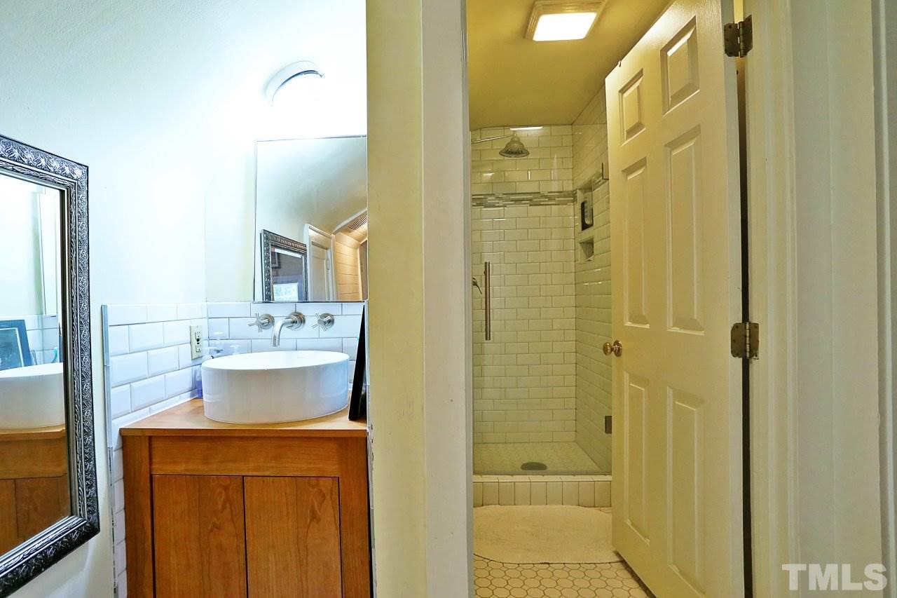 526 North Person Street Raleigh, NC 27604 - Photo 19 of 25 a bathroom with a granite countertop sink a mirror and a shower