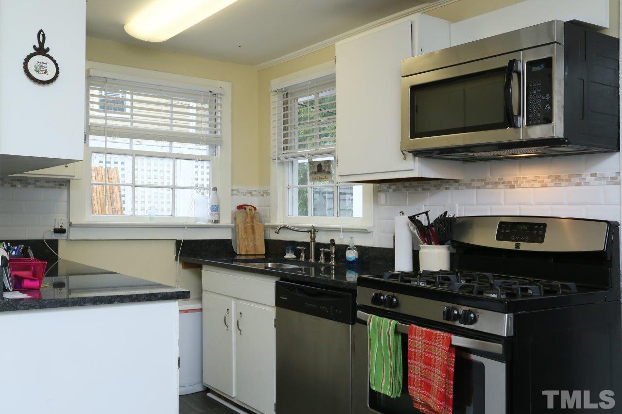 526 North Person Street Raleigh, NC 27604 - Photo 8 of 25 a kitchen with stainless steel appliances granite countertop a sink stove and microwave