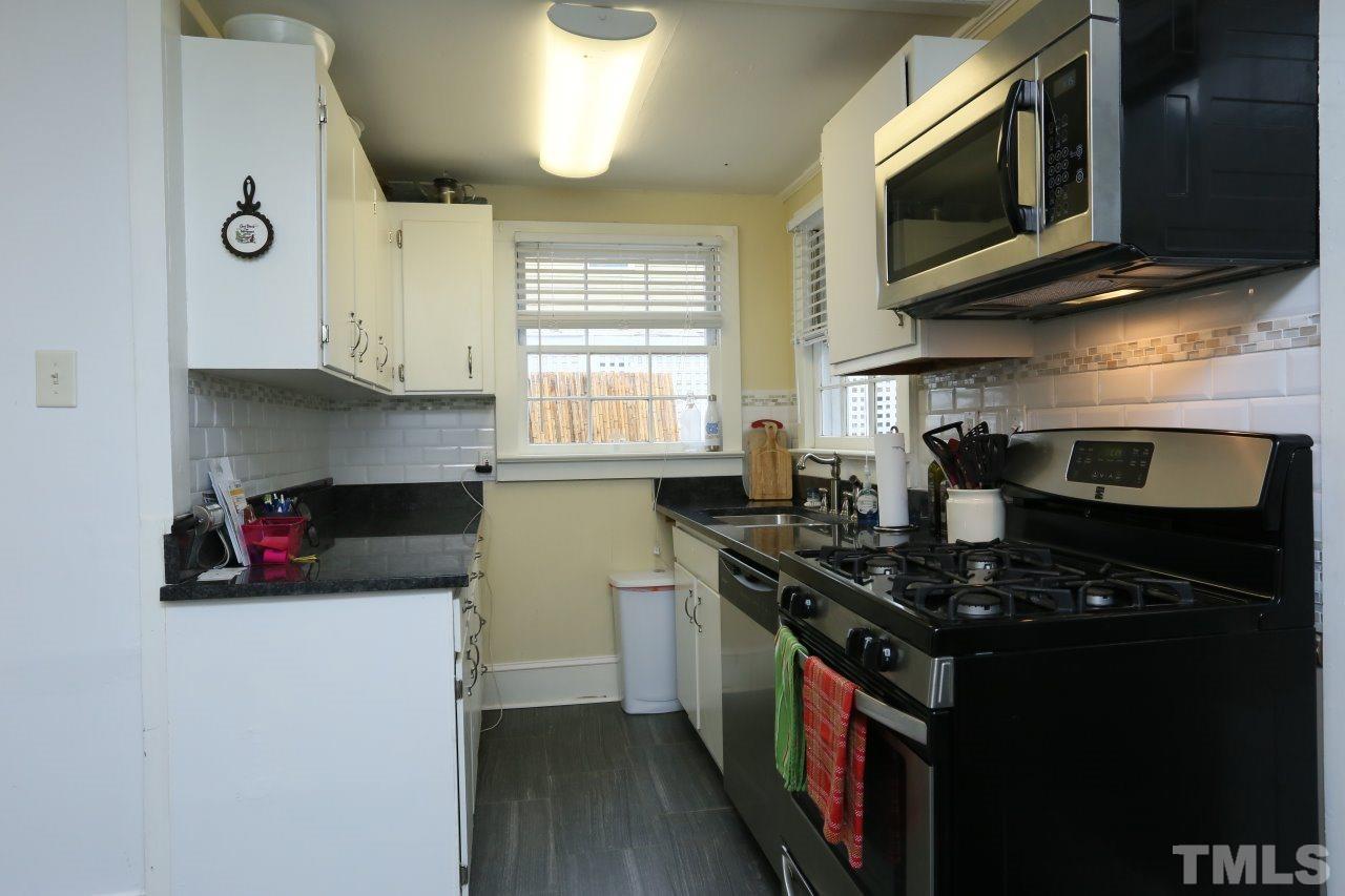 526 North Person Street Raleigh, NC 27604 - Photo 9 of 25 a kitchen with stainless steel appliances a stove a microwave and cabinets