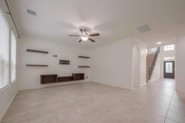 an empty room with windows and fan