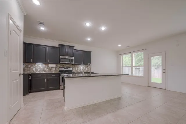 a kitchen with stainless steel appliances granite countertop a stove sink and cabinets