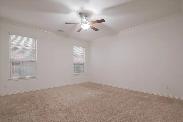 an empty room with windows and fan