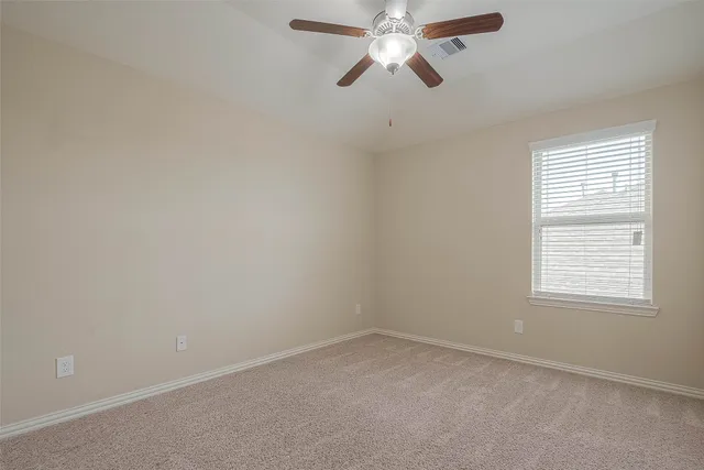 an empty room with a window and a fan