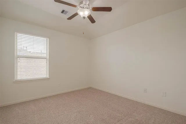 an empty room with a window and a fan