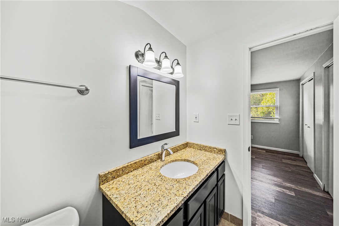 1796 Lander Road Mayfield Heights, OH 44124 - Photo 31 of 39 Bathroom featuring vaulted ceiling, vanity, hardwood / wood-style floors, and toilet