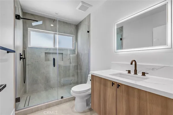 a bathroom with a granite countertop sink toilet and shower