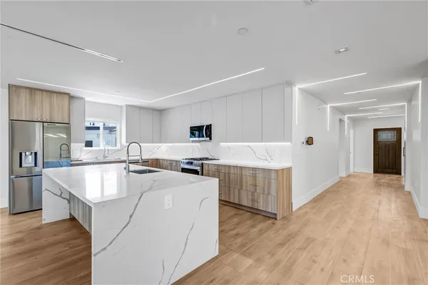 a large white kitchen with wooden floor