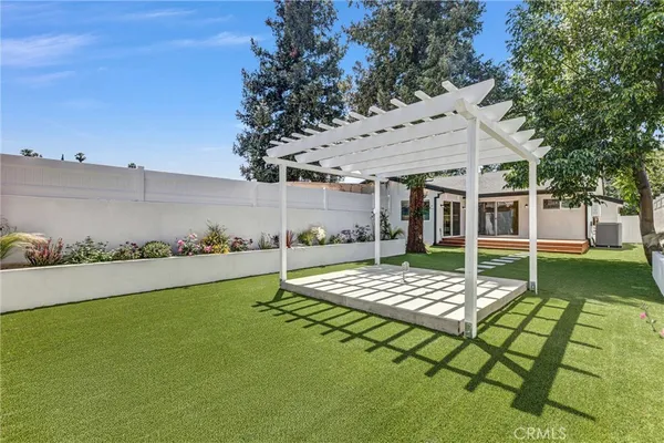 a view of a house with backyard and sitting area