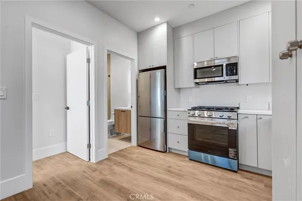 a kitchen with stainless steel appliances a stove a microwave and a refrigerator