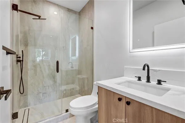 a bathroom with a granite countertop sink toilet and shower