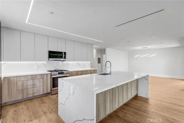 a kitchen with stainless steel appliances granite countertop a white stove top oven and white cabinets