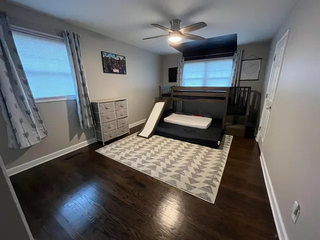 a bedroom with wooden floor bed and a window