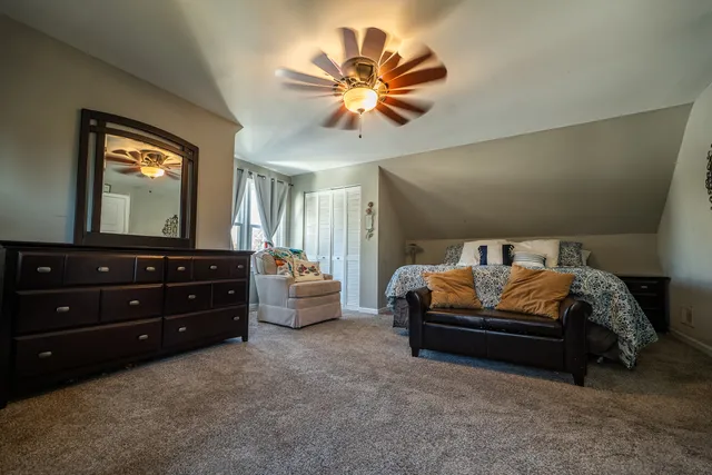 a spacious bedroom with a bed and a chandelier