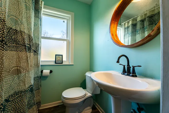 a bathroom with a toilet sink and mirror