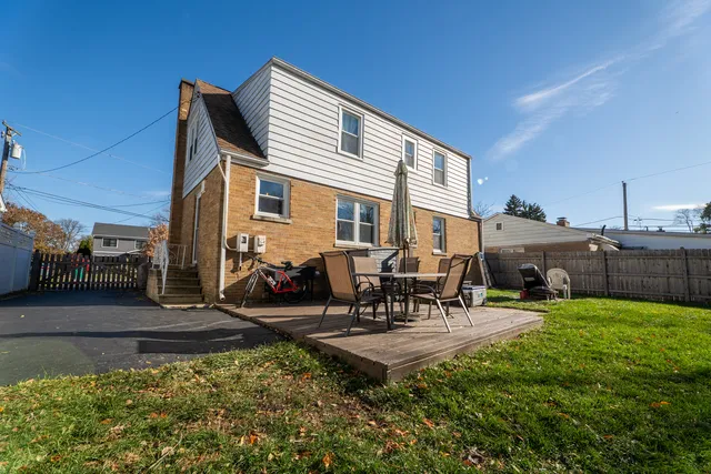 a view of a patio with table and chairs potted plants and a large tree