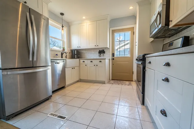a kitchen with a refrigerator a stove top oven and cabinets