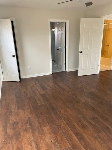 a view of an empty room with wooden floor and staircase