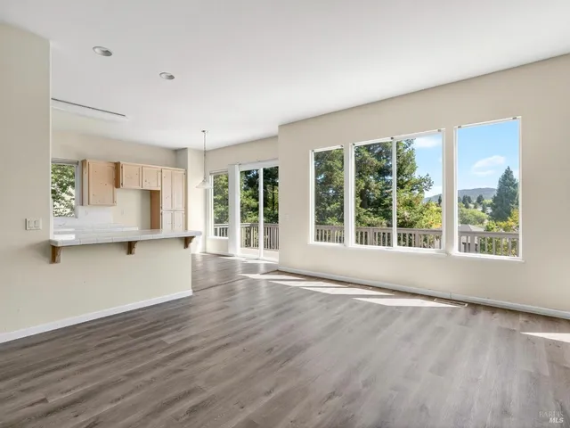 a view of empty room with wooden floor and fireplace