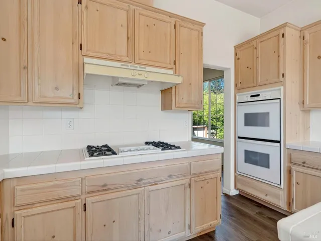 a bathroom with a granite countertop sink a toilet and a mirror