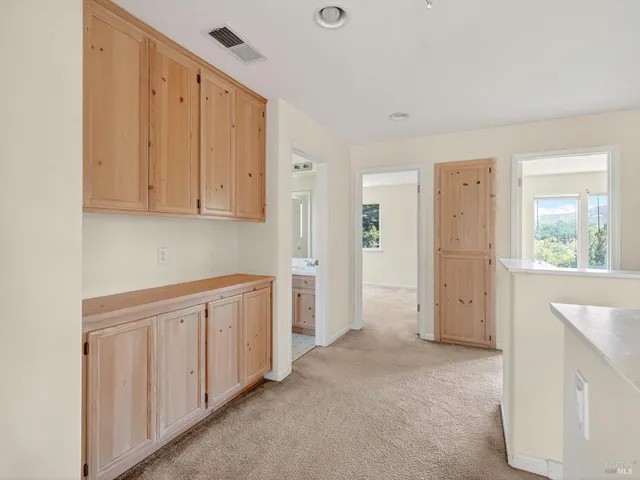 a view of a hallway with white walls and wooden floor