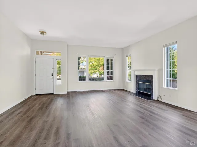 a view of a hallway with wooden floor and stairs
