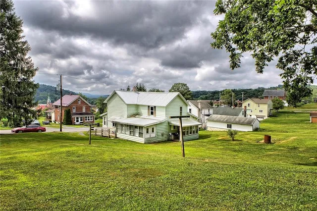 a view of a house with a big yard and a large tree
