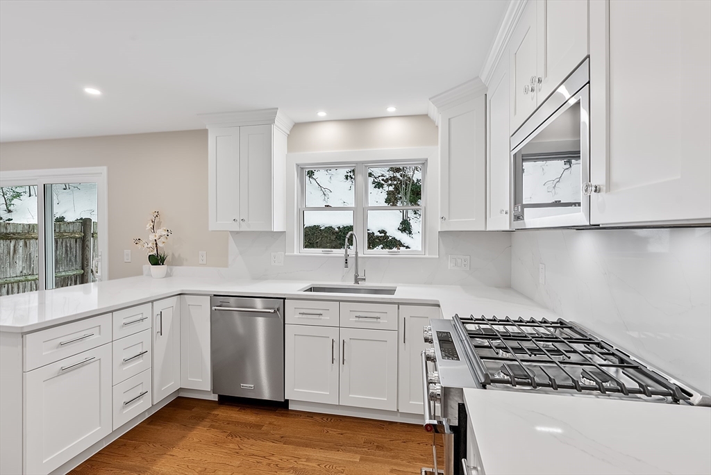 a kitchen with white cabinets and appliances