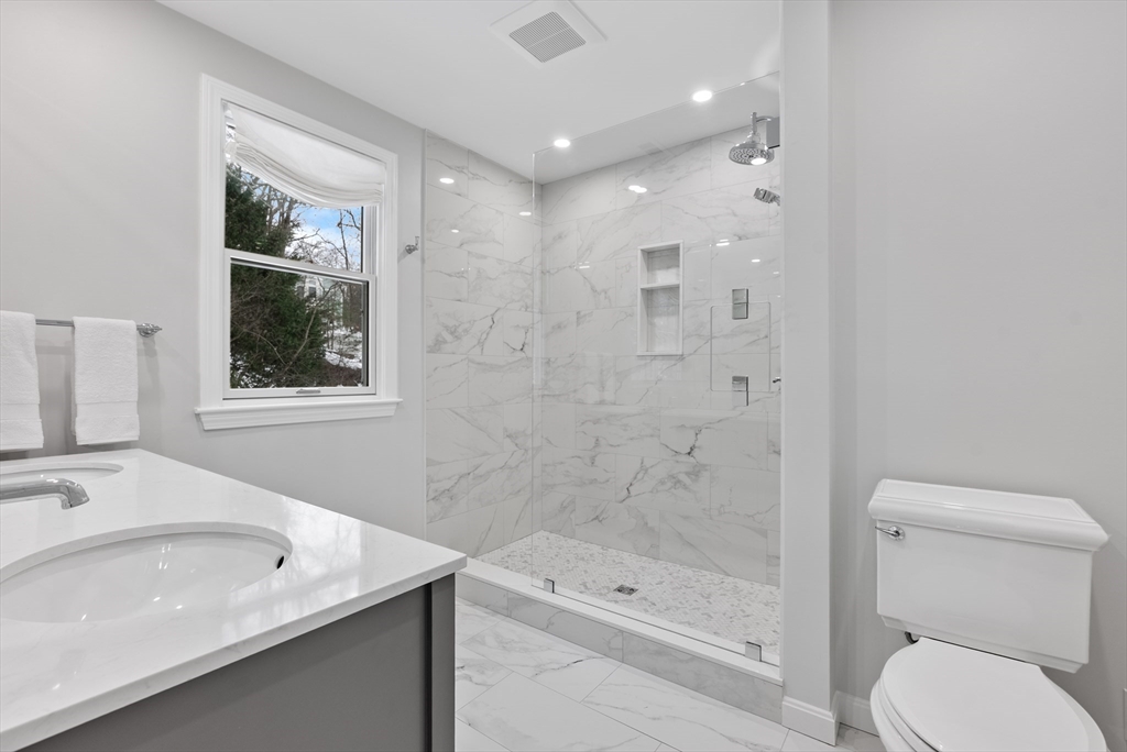 34 Pleasant Street, Unit 5 Wellesley, MA 02482 - Photo 11 of 31 a bathroom with a bathtub shower sink vanity and toilet