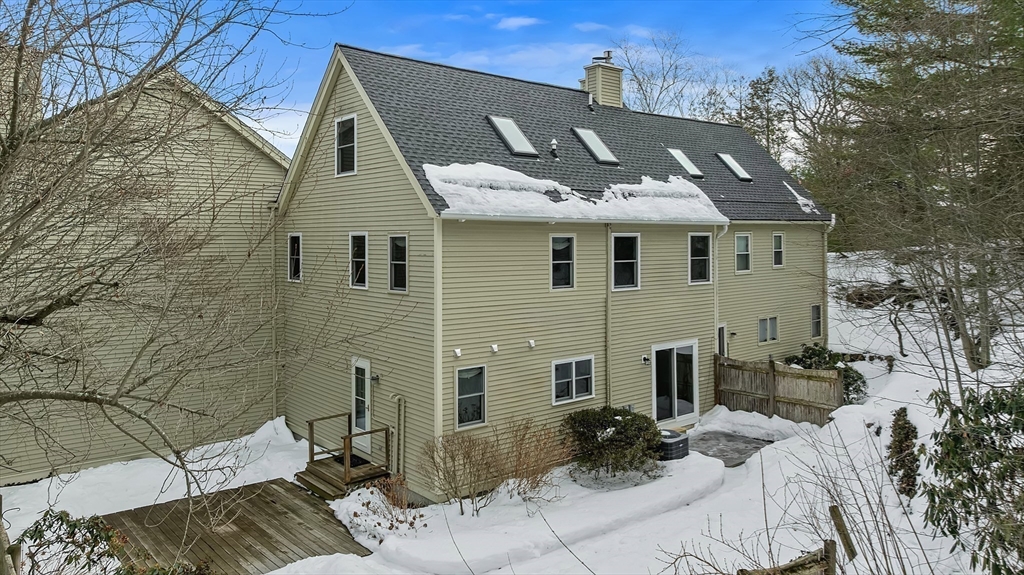 34 Pleasant Street, Unit 5 Wellesley, MA 02482 - Photo 25 of 31 a view of a white house with large windows and couches chairs