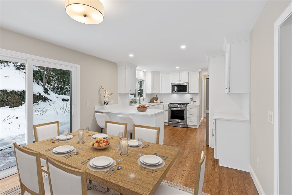 34 Pleasant Street, Unit 5 Wellesley, MA 02482 - Photo 3 of 31 a open dining room with stainless steel appliances granite countertop a table chairs and white cabinets