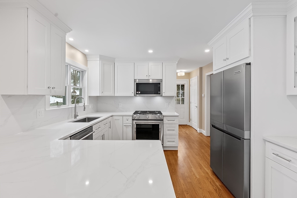 34 Pleasant Street, Unit 5 Wellesley, MA 02482 - Photo 8 of 31 a kitchen with a refrigerator a stove a microwave and cabinets