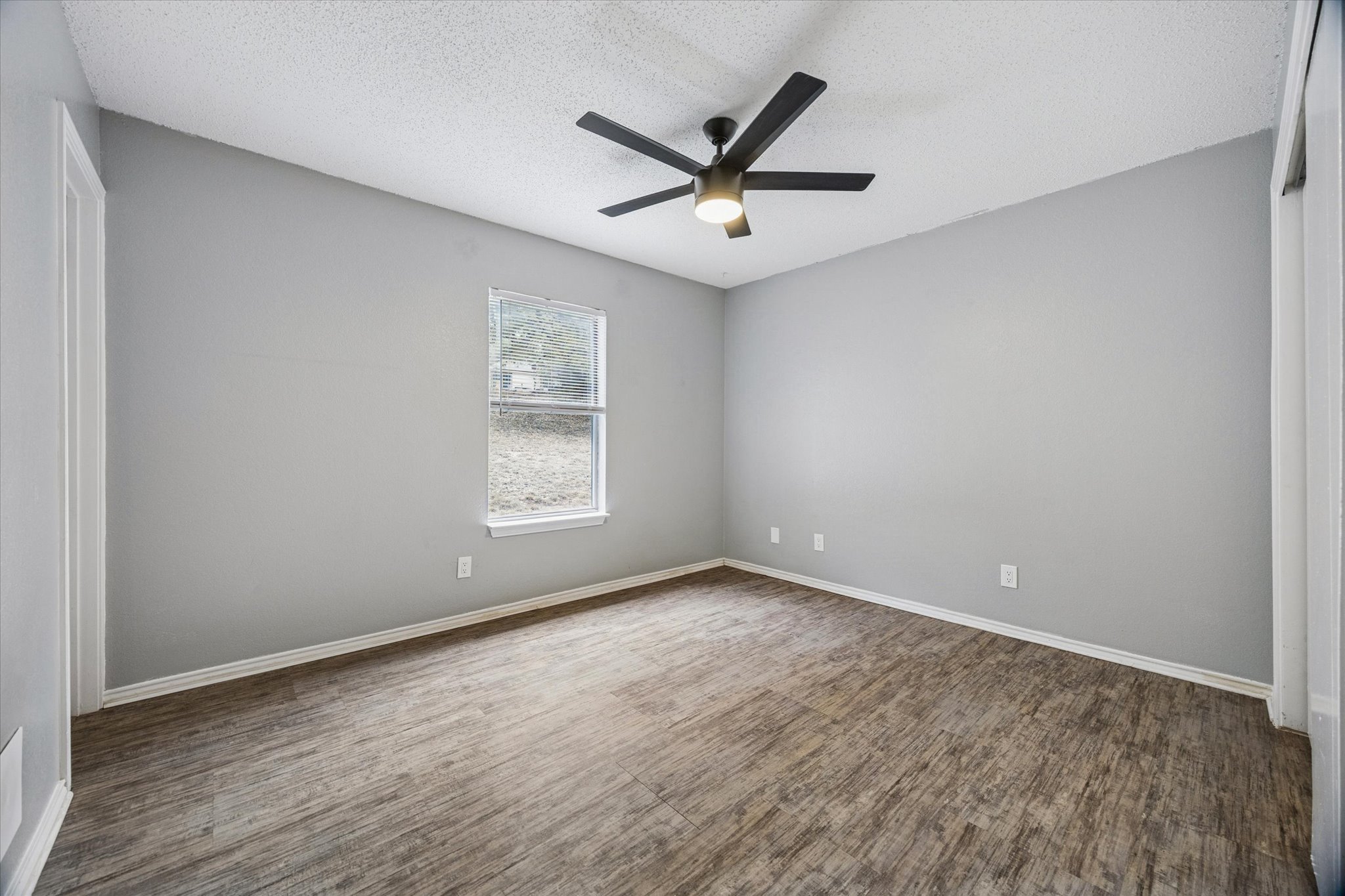 23393 Nameless Road, Unit 152 Leander, TX 78641 - Photo 7 of 10 Unfurnished room with a textured ceiling, a ceiling fan, and dark wood-type flooring