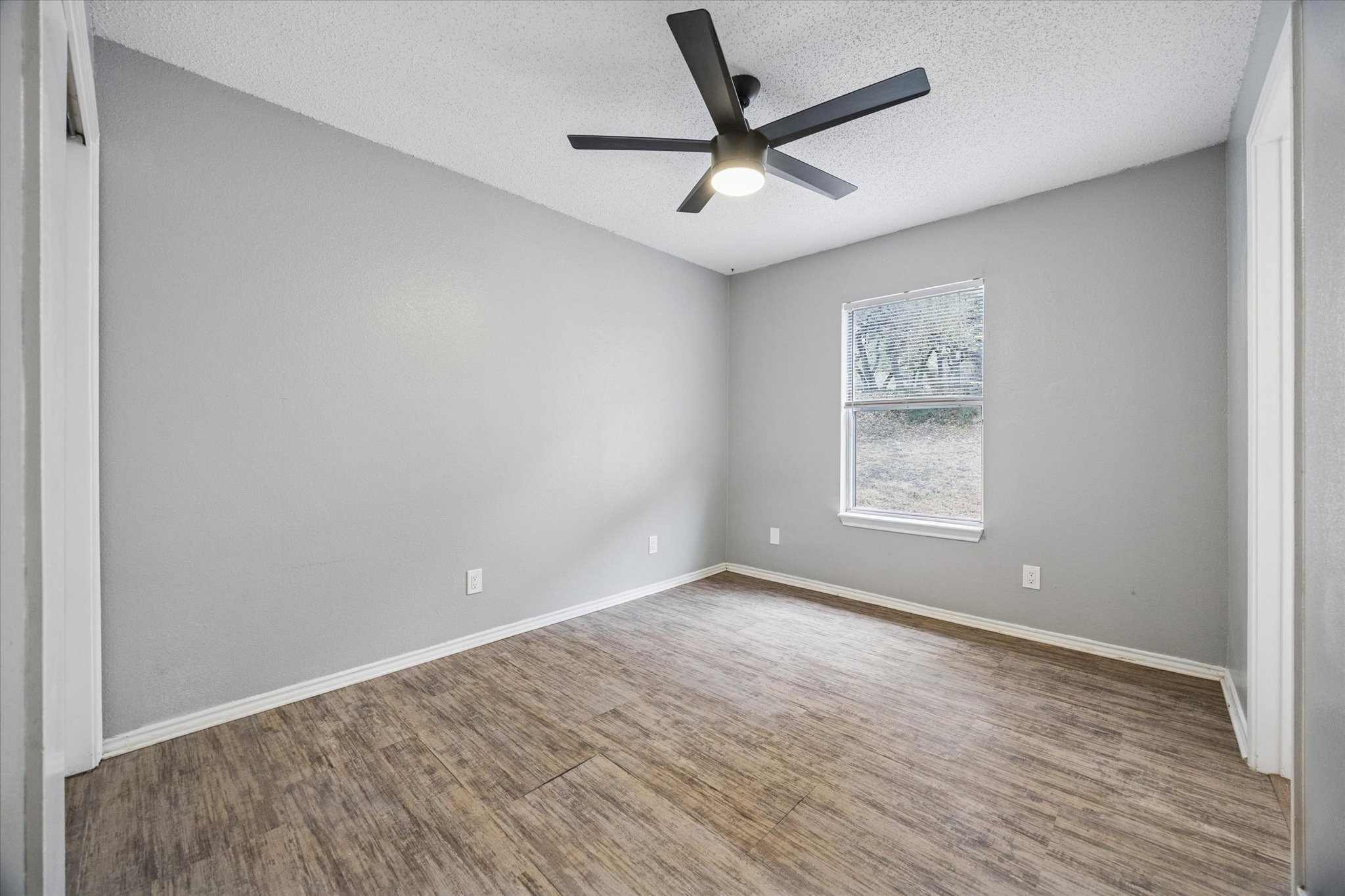 23393 Nameless Road, Unit 152 Leander, TX 78641 - Photo 8 of 10 Spare room featuring a ceiling fan, a textured ceiling, and wood finished floors