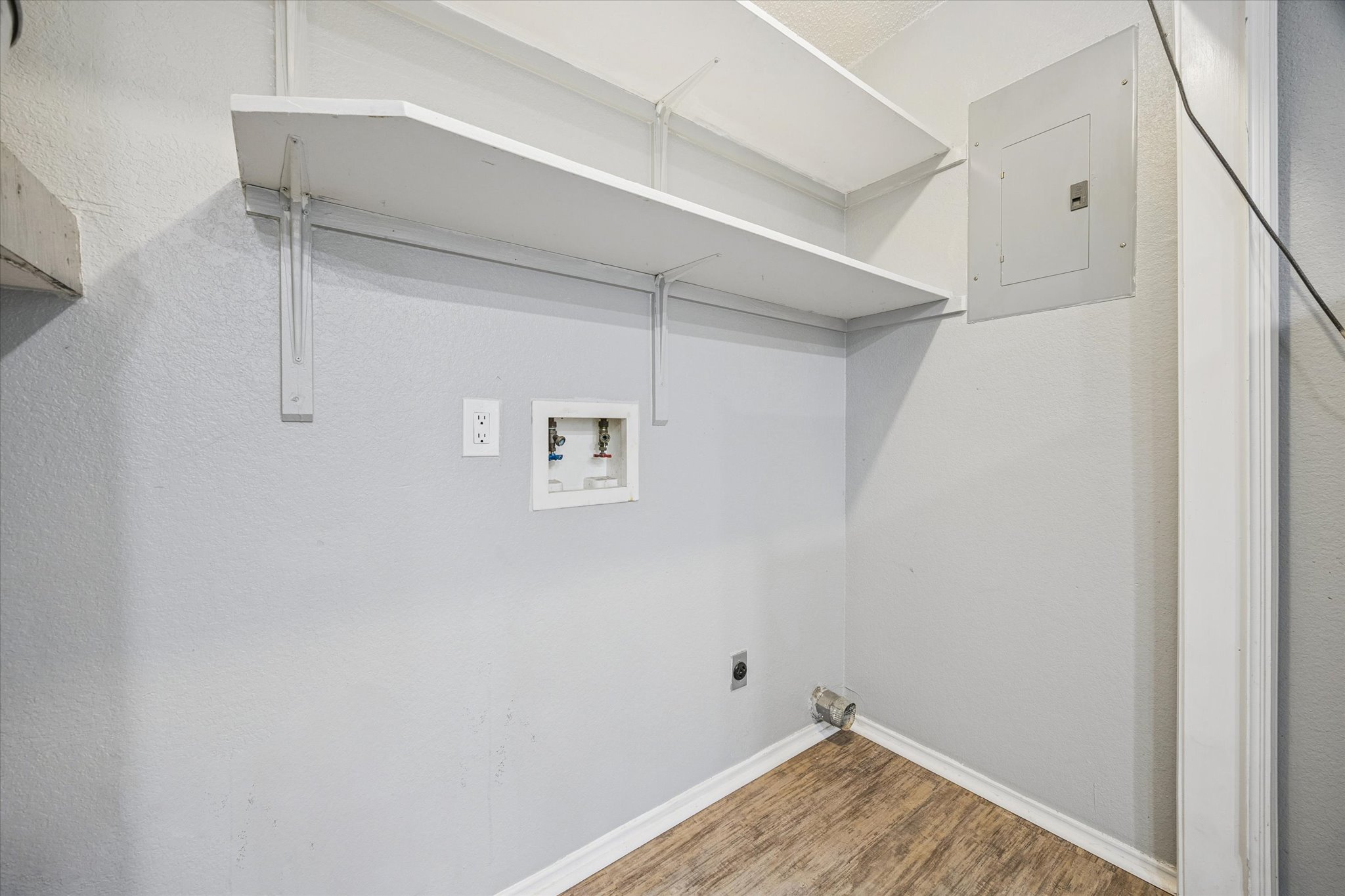 23393 Nameless Road, Unit 152 Leander, TX 78641 - Photo 10 of 10 Laundry room featuring electric panel, wood finished floors, washer hookup, and hookup for an electric dryer