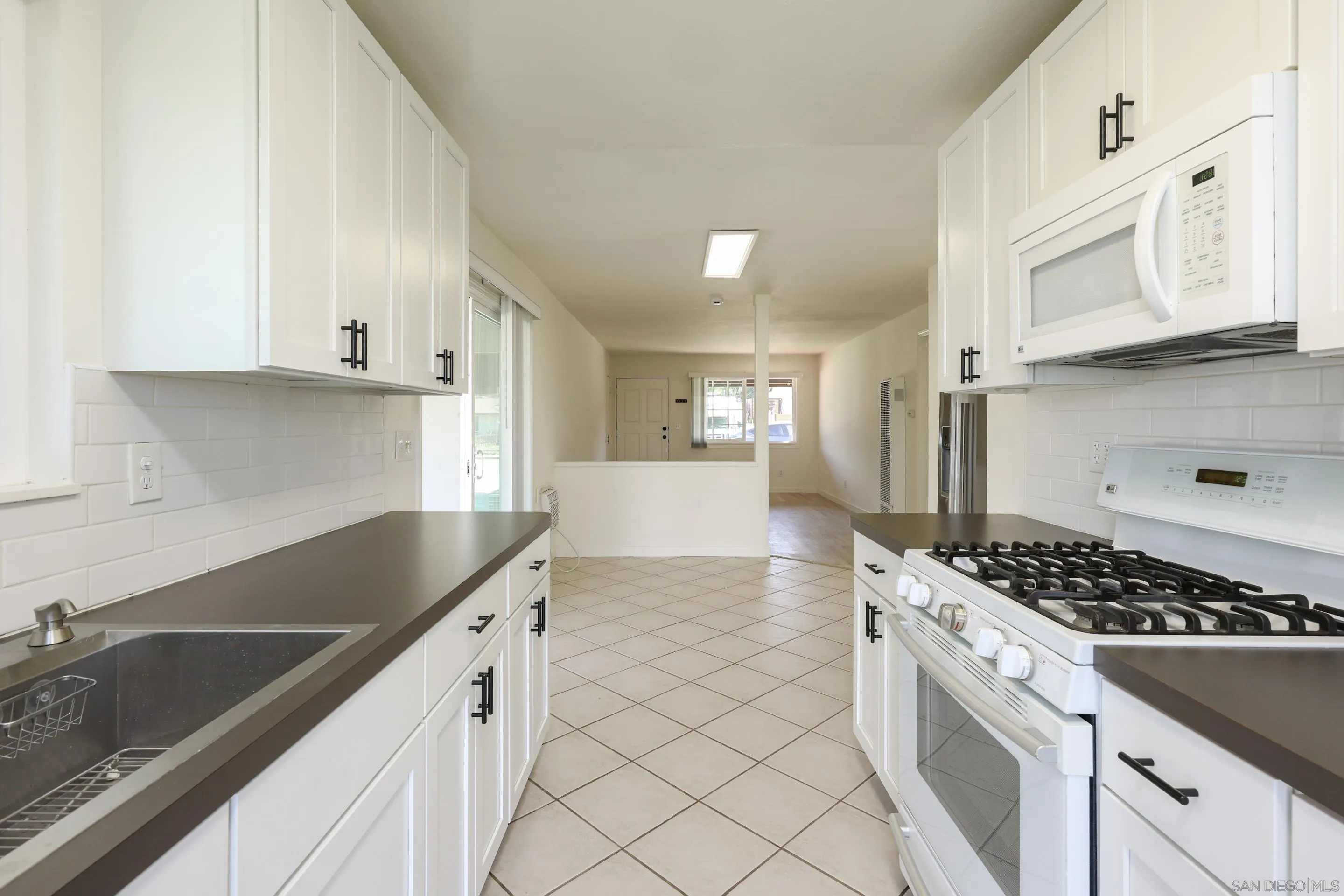 11102 Shadow Hill Way Santee, CA 92071 - Photo 11 of 30 a kitchen with granite countertop a sink stove and cabinets