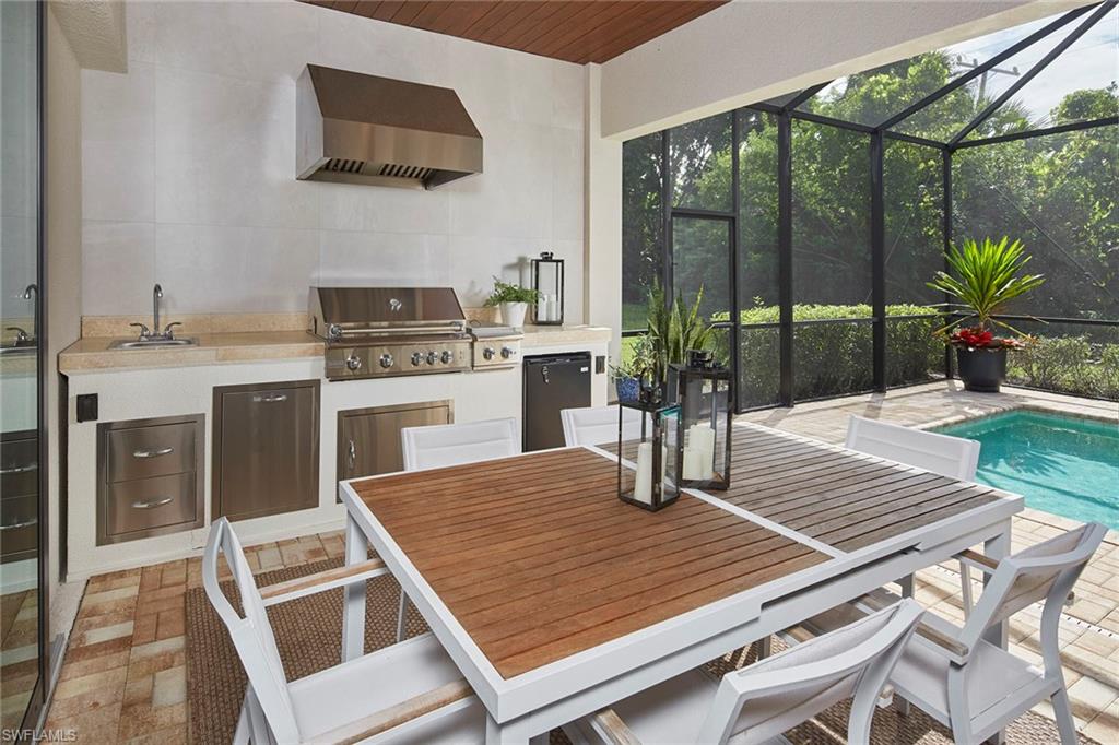 2863 Coco Lakes Drive Naples, FL 34105 - Photo 13 of 39 a kitchen with a stove a sink and a wooden floor
