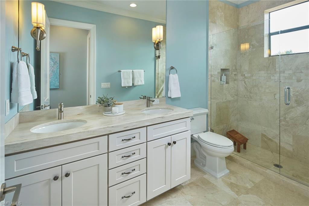 2863 Coco Lakes Drive Naples, FL 34105 - Photo 32 of 39 a bathroom with a toilet a sink a light fixture and a mirror