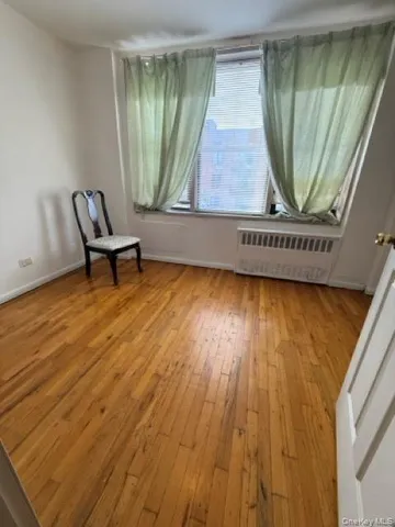 a view of a room with wooden floor and a window