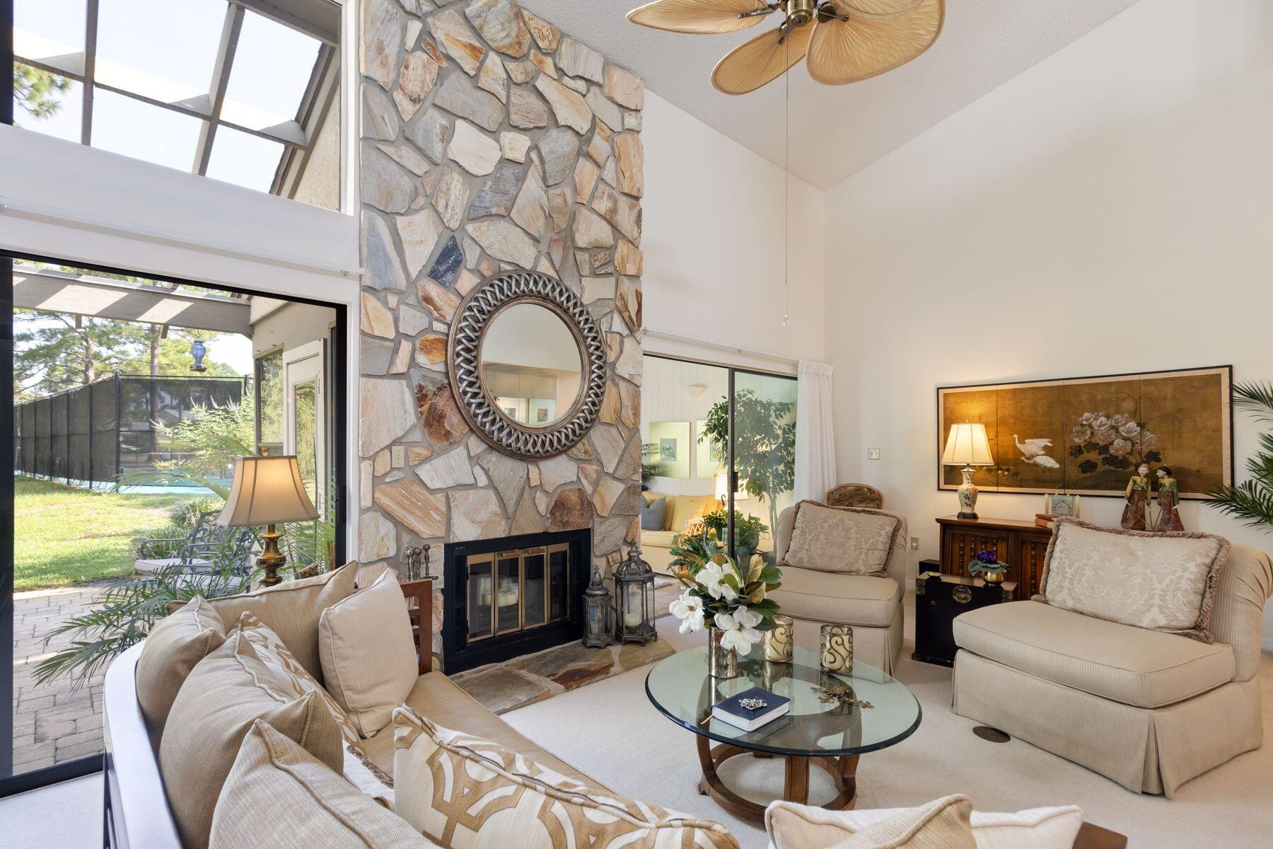 a living room with furniture a fireplace and a large window
