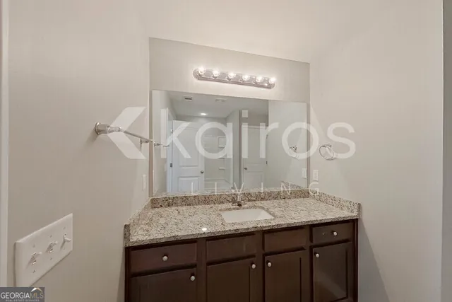 a bathroom with a granite countertop sink a large mirror and a