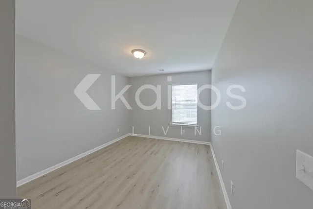 a view of a room with wooden floor and white walls