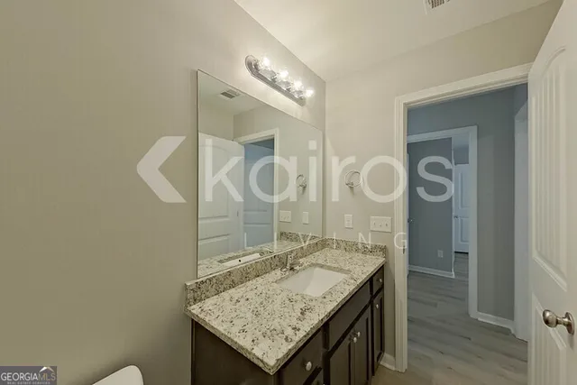 a bathroom with a granite countertop sink a mirror and a shower