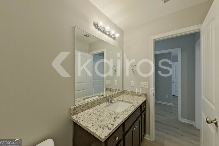 105 Colonial Way Springfield, GA 31329 - Photo 23 of 30 a bathroom with a granite countertop sink a mirror and a shower