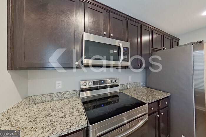105 Colonial Way Springfield, GA 31329 - Photo 10 of 30 a kitchen with a stove and a wooden floor