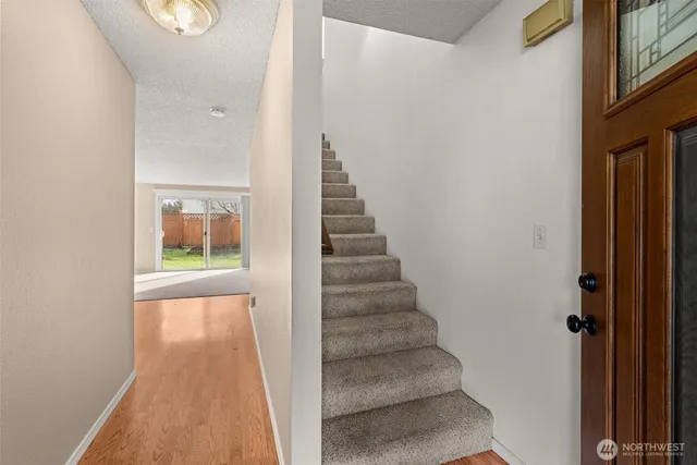 a view of a hallway with wooden floor and closet