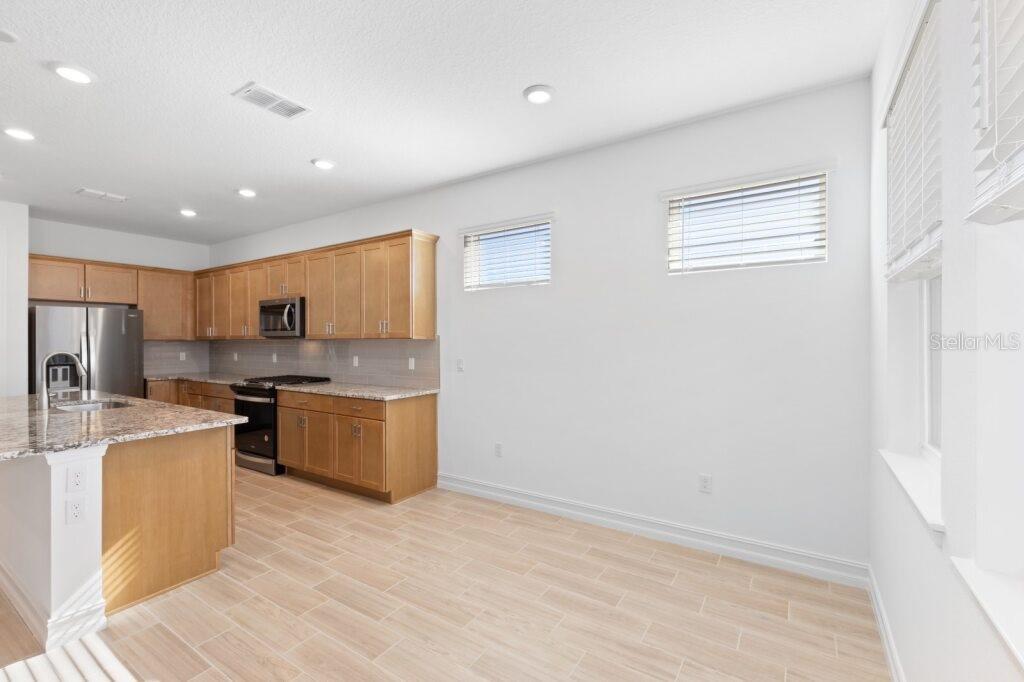 3320 Northwest 52nd Avenue Road Ocala, FL 34482 - Photo 12 of 25 a kitchen with stainless steel appliances granite countertop a refrigerator a sink dishwasher a oven with white cabinets