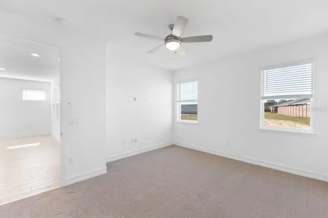 an empty room with a window and a fan