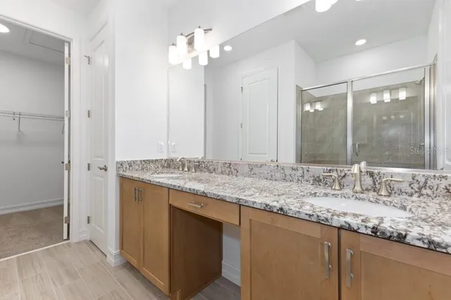 a bathroom with a granite countertop sink and a mirror