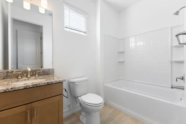 a bathroom with a granite countertop toilet sink and mirror